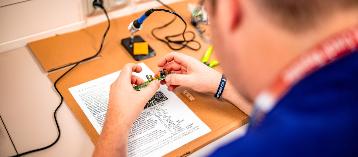 A student at a soldering station at Youngsters on the Air (YOTA) Summer Camp 2024